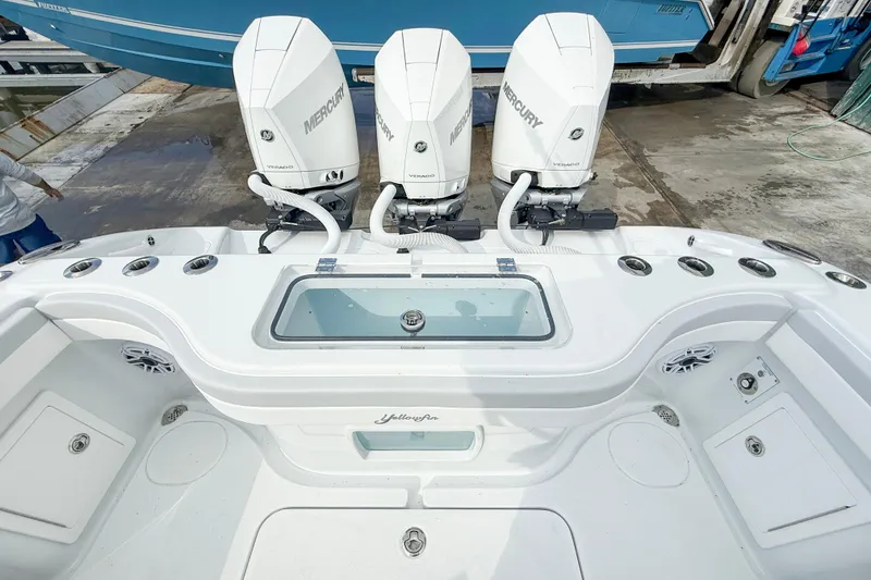 Slide: The Image of 2024 Yellowfin 34 Offshore boat with triple Mercury Verado engines, docked at marina. - 22