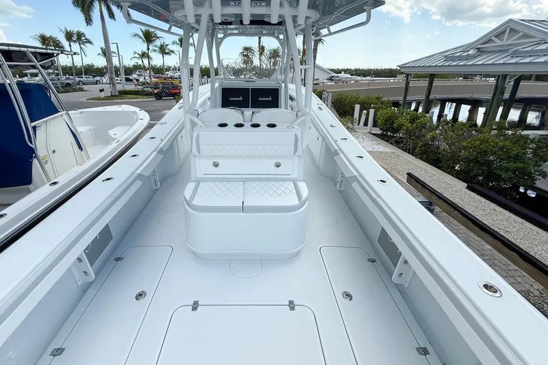 Slide: The Image of 2024 Yellowfin 34 Offshore boat interior with seating and console, docked near palm trees. - 23