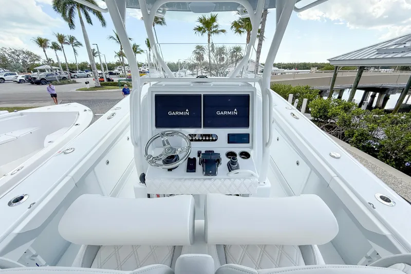 Slide: The Image of 2024 Yellowfin 34 Offshore boat helm with Garmin navigation system, docked near palm trees. - 3