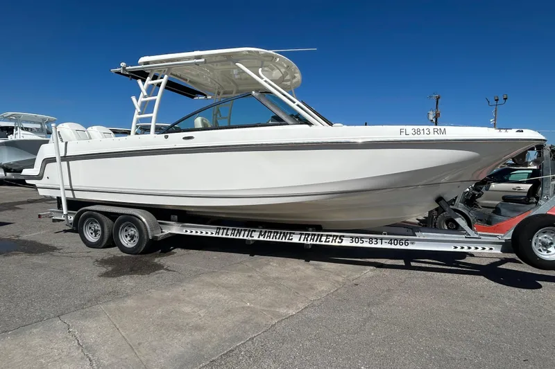 The Image of 2018 Boston Whaler 270 Vantage boat on trailer, parked outdoors under clear blue sky. - 0