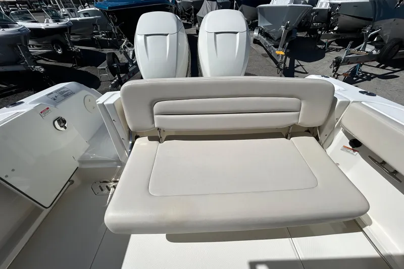 Slide: The Image of 2018 Boston Whaler 270 Vantage boat interior with cushioned seating and dual engines. - 10
