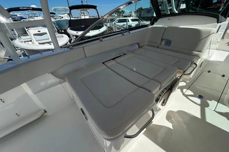 Slide: The Image of 2018 Boston Whaler 270 Vantage boat interior with cushioned seating and stainless steel fixtures. - 13