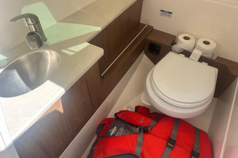 Slide: The Image of 2018 Boston Whaler 270 Vantage boat bathroom with sink, toilet, and life jacket. - 21
