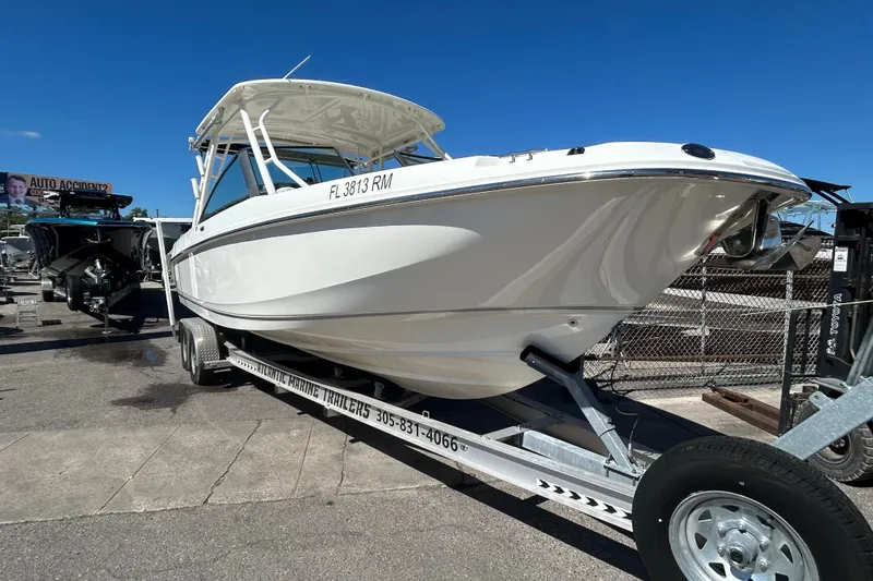 Slide: The Image of 2018 Boston Whaler 270 Vantage boat on trailer, parked outdoors under clear blue sky. - 3
