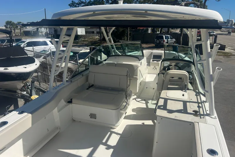 Slide: The Image of 2018 Boston Whaler 270 Vantage boat interior with seating and helm, docked outdoors. - 7