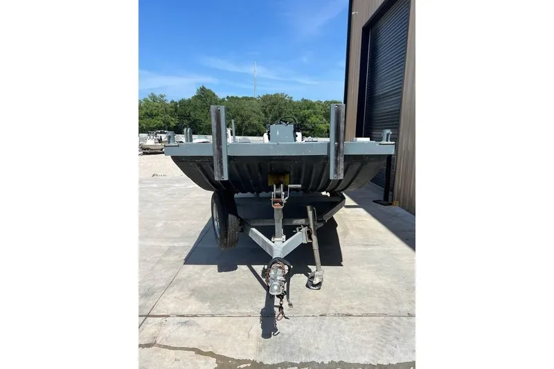 Slide: The Image of 1999 Aluminum Boat on trailer, parked outside a building under clear blue sky. - 3