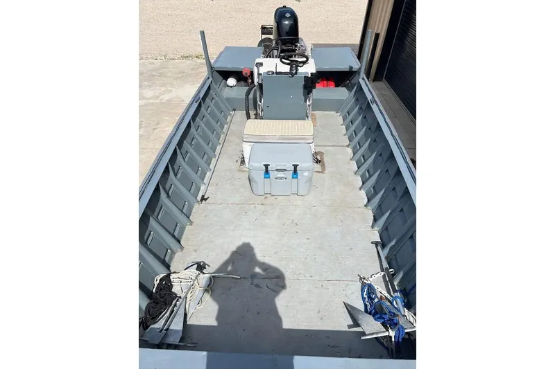 Slide: The Image of 1999 Aluminum Boat interior with steering console, cooler, and anchor. - 9
