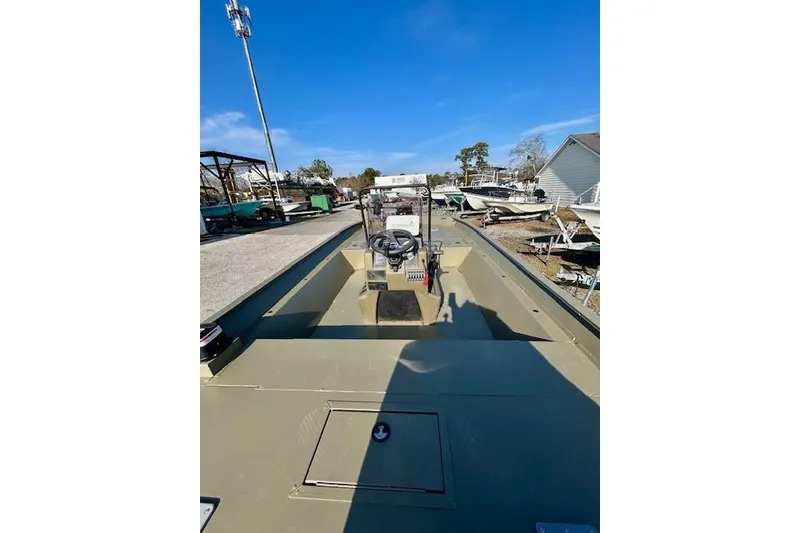 Slide: The Image of 2021 Tracker Grizzly 2072 CC boat with center console, parked outdoors under clear blue sky. - 12