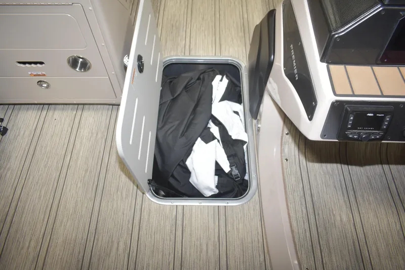 Slide: The Image of Storage compartment in 2026 Premier 230 Solaris RL boat, containing black and white items. - 22