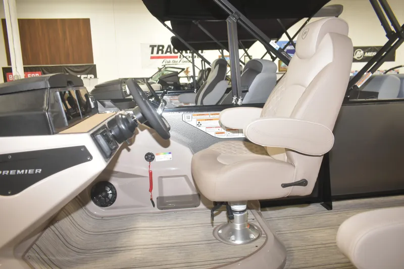 Slide: The Image of Interior of 2026 Premier 230 Solaris RL boat, featuring a beige captain's chair and steering console. - 8
