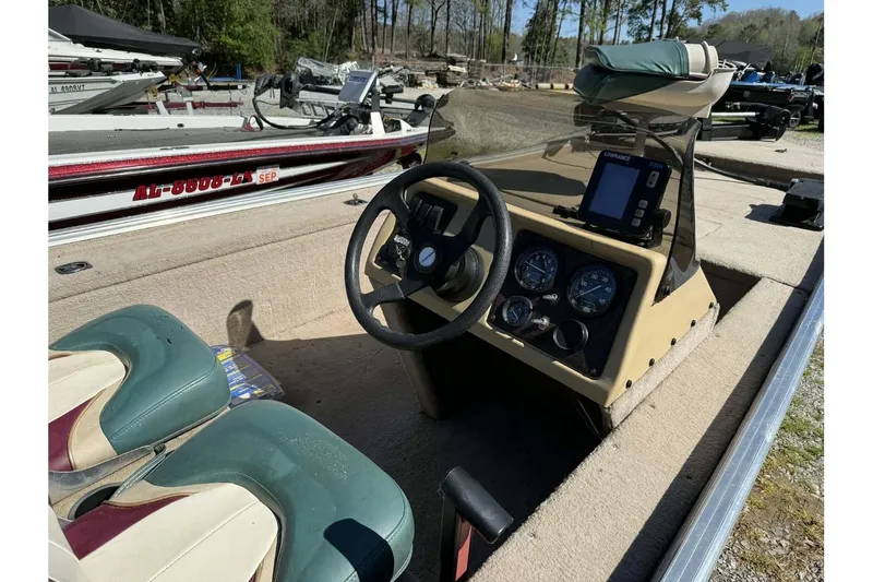 Slide: The Image of 1997 Fisher 1600 boat interior with steering wheel, gauges, and seating. - 11