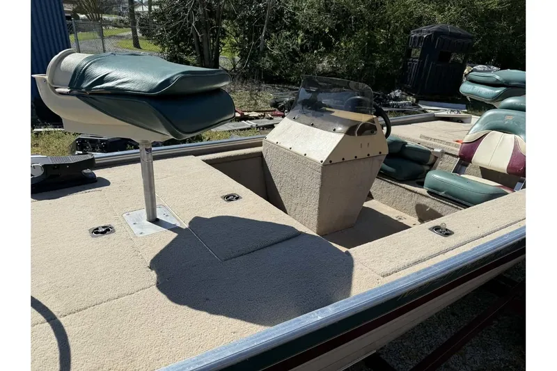 Slide: The Image of 1997 Fisher 1600 boat interior with green seats and steering console. - 3