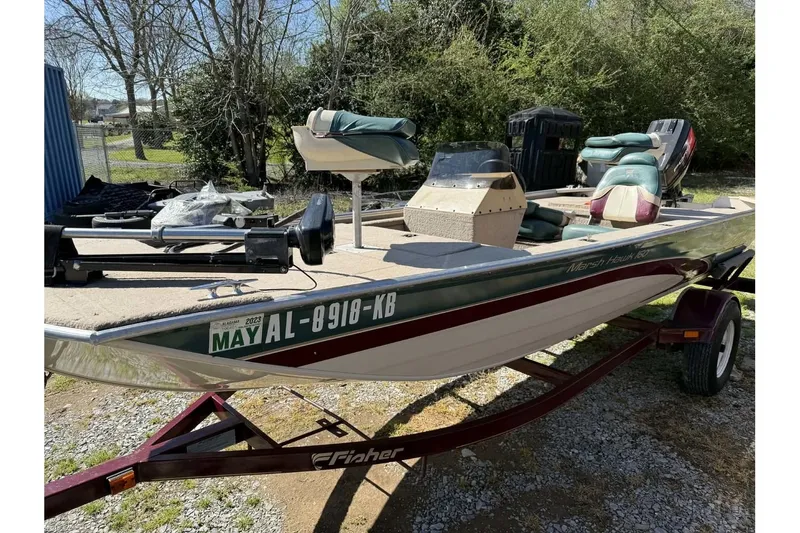 Slide: The Image of 1997 Fisher 1600 boat on trailer, parked outdoors with registration visible. - 5