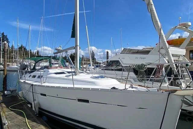 Slide: The Image of 2005 Beneteau Oceanis 373 sailboat docked in a marina under a clear blue sky. - 2