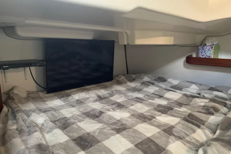 Slide: The Image of Cozy cabin interior of 2005 Beneteau Oceanis 373 with TV and checkered bedding. - 24