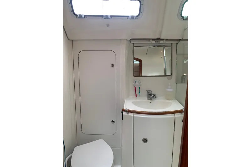 Slide: The Image of Bathroom interior of 2005 Beneteau Oceanis 373 yacht, featuring sink, mirror, and storage. - 26