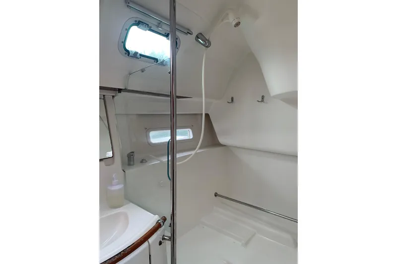 Slide: The Image of Bathroom interior of 2005 Beneteau Oceanis 373 sailboat, featuring shower and porthole window. - 28