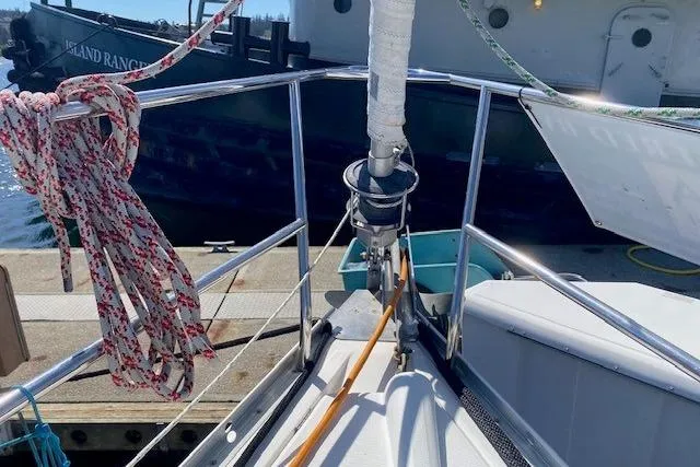 Slide: The Image of Bow of a 2005 Beneteau Oceanis 373 sailboat docked, with ropes and railing visible. - 32