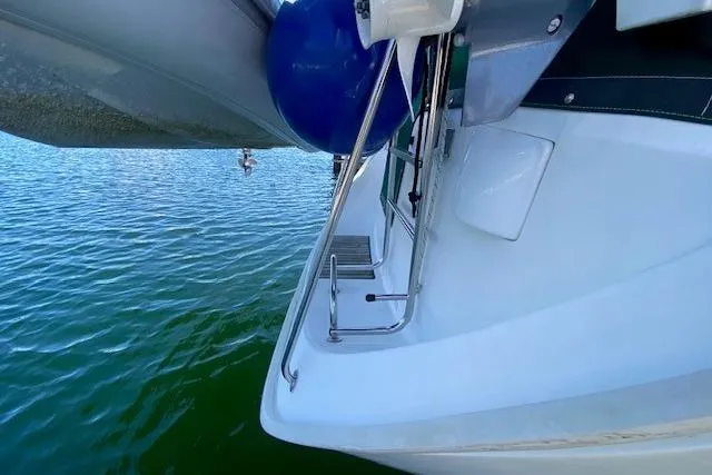 Slide: The Image of 2005 Beneteau Oceanis 373 sailboat stern with blue fender on calm water. - 42