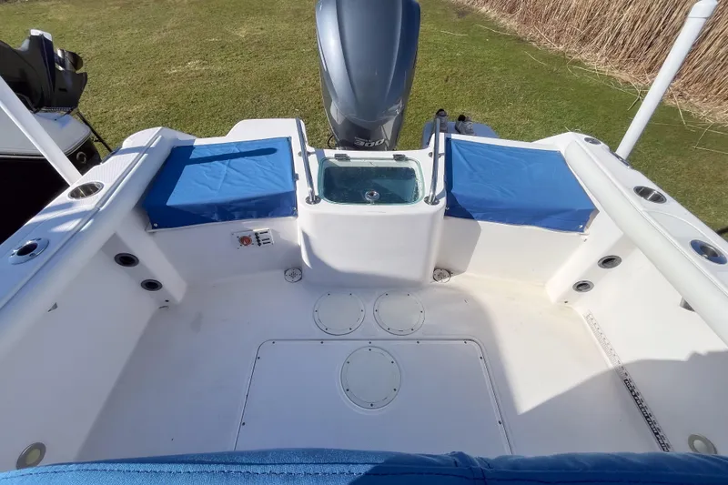Slide: The Image of 2013 Everglades 230 Center Console boat interior with blue seating and engine view. - 1