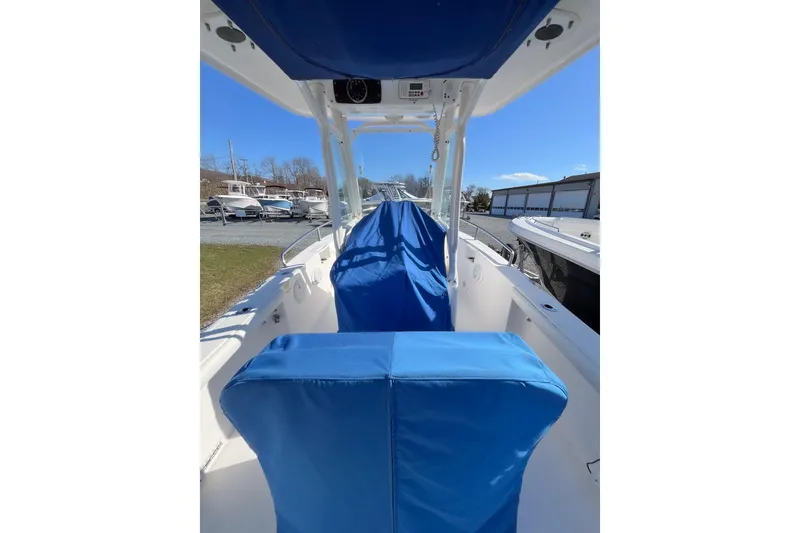 Slide: The Image of 2013 Everglades 230 Center Console boat with blue seat covers, docked outdoors. - 3