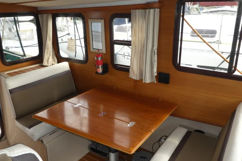 Slide: The Image of Interior of 2015 Ranger Tugs R-25 SC with wooden table and seating area. - 10