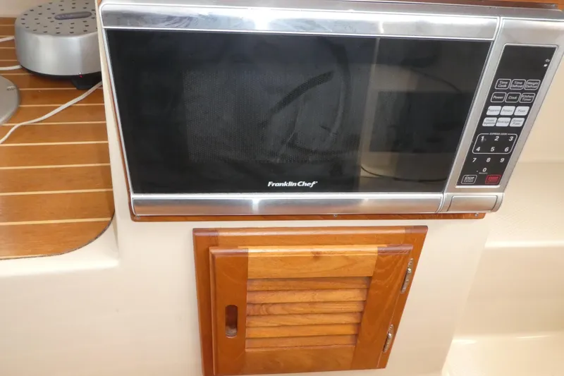 Slide: The Image of Microwave and wooden cabinet in 2015 Ranger Tugs R-25 SC boat interior. - 14