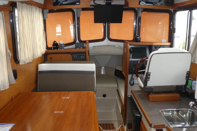 Slide: The Image of Interior of 2015 Ranger Tugs R-25 SC boat with seating, helm, and kitchenette. - 15