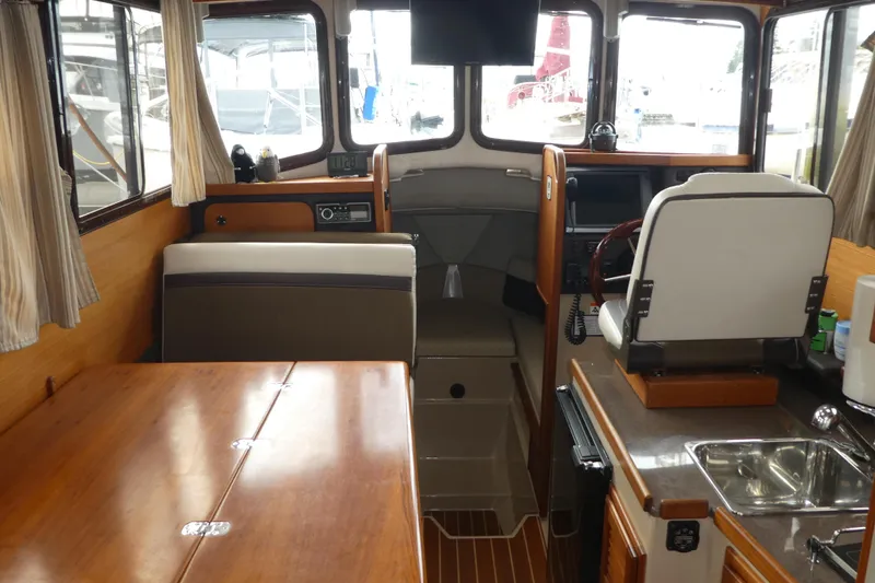 Slide: The Image of Interior of 2015 Ranger Tugs R-25 SC boat with helm, seating, and kitchenette. - 16