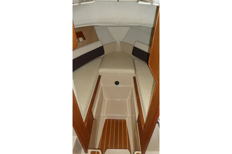 Slide: The Image of 2015 Ranger Tugs R-25 SC cabin interior with cushioned seating and wood accents. - 17