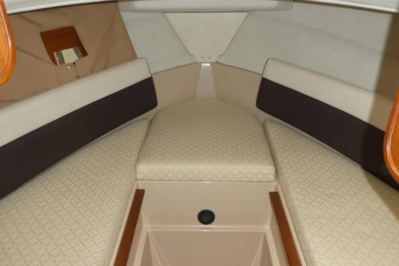 Slide: The Image of 2015 Ranger Tugs R-25 SC cabin interior with beige cushioned seating. - 18