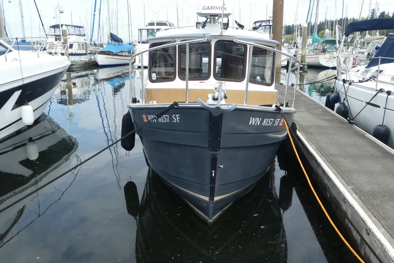 Slide: The Image of 2015 Ranger Tugs R-25 SC docked at a marina, surrounded by other boats. - 23