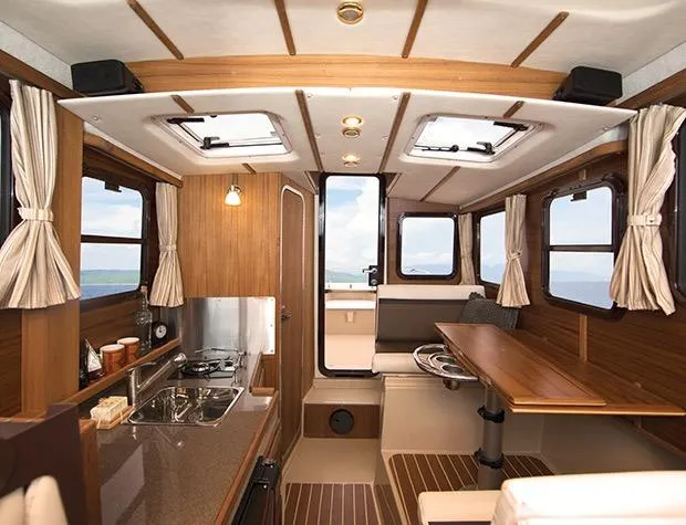 Slide: The Image of Manufacturer Provided Image: 2015 Ranger Tugs R-25SC interior with kitchen, dining area, and windows. - 32