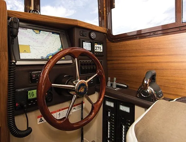 Slide: The Image of Manufacturer Provided Image: 2015 Ranger Tugs R-25SC helm with wooden steering wheel, navigation system, and control panel. - 33