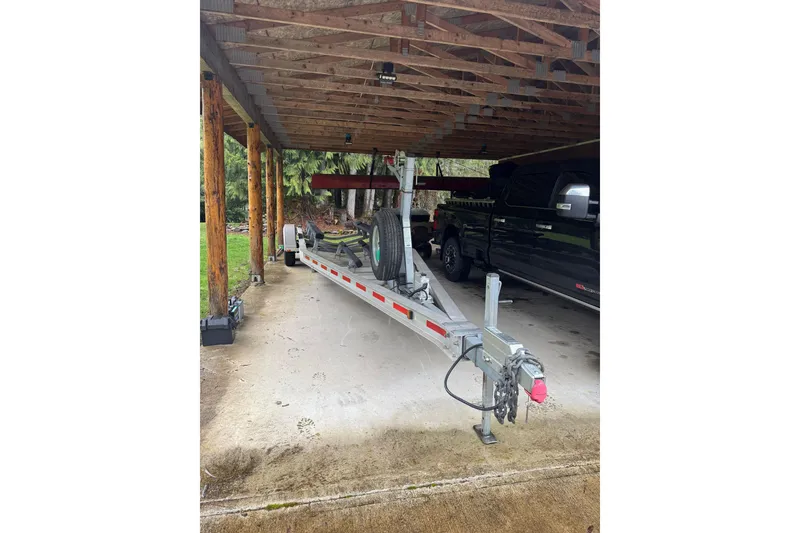 Slide: The Image of Covered trailer for 2015 Ranger Tugs R-25 SC, parked beside a black truck. - 35