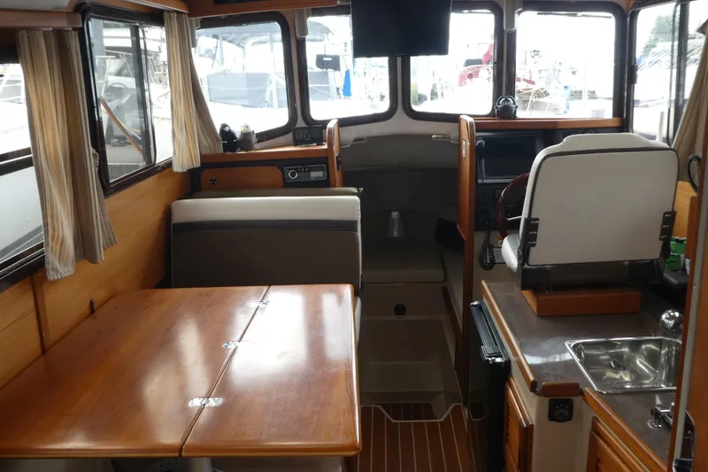 Slide: The Image of Interior of 2015 Ranger Tugs R-25 SC boat with dining area and helm station. - 4
