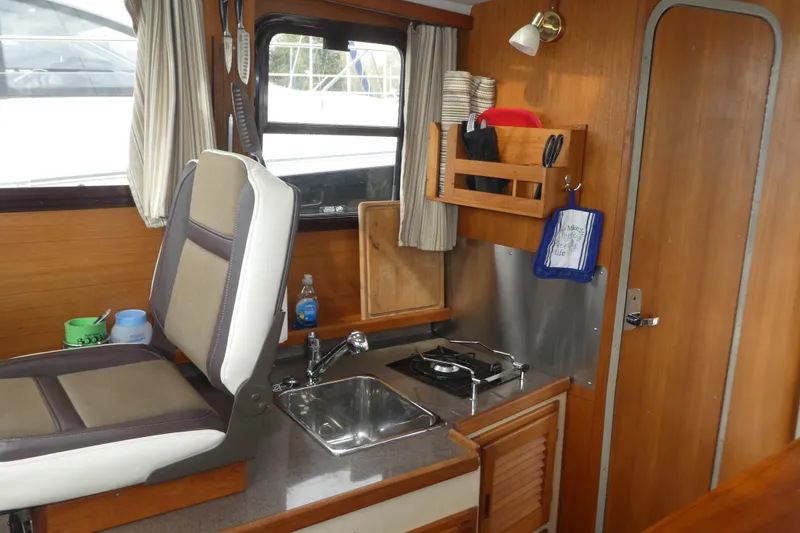 Slide: The Image of Interior of 2015 Ranger Tugs R-25 SC boat with compact kitchen area. - 8