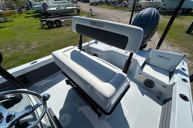 Slide: The Image of 2026 Pathfinder 2500 Hybrid boat interior with seating and steering wheel, parked outdoors. - 14
