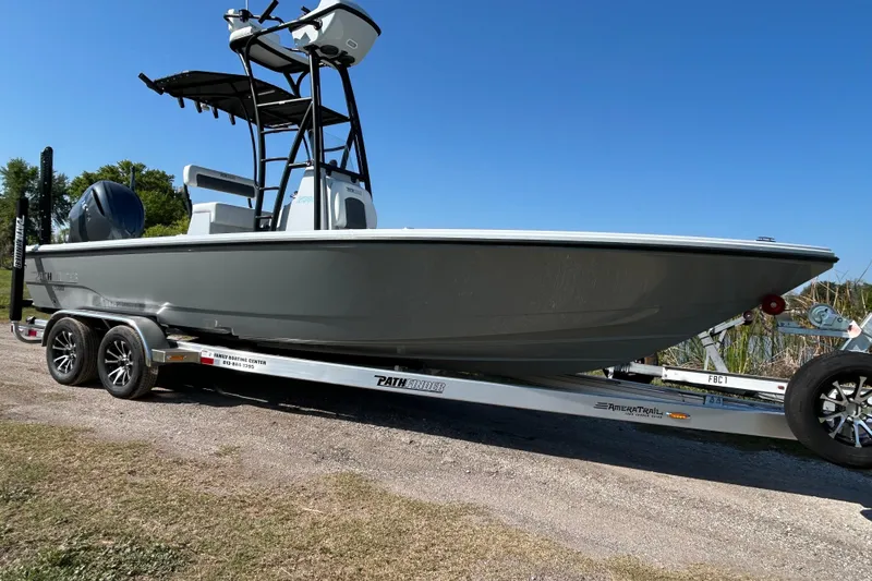 Slide: The Image of 2026 Pathfinder 2500 Hybrid boat on trailer, parked outdoors under clear blue sky. - 3