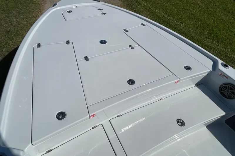 Slide: The Image of 2026 Pathfinder 2500 Hybrid boat deck with storage compartments, shown on grass. - 9