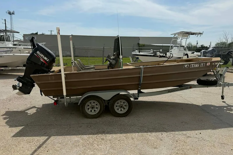 Slide: The Image of 2014 Southfork 1860 boat on trailer with Suzuki outboard motor, parked outdoors. - 2