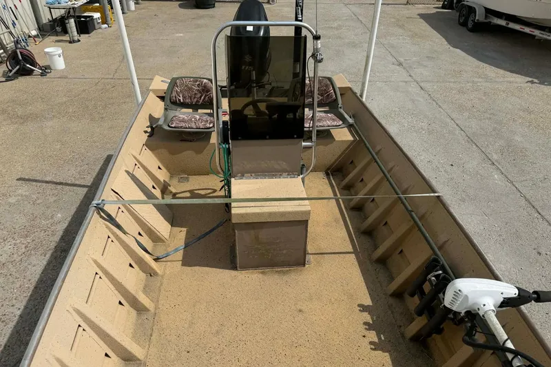 Slide: The Image of 2014 Southfork 1860 boat interior with steering console and seating, parked on concrete. - 7