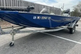 Slide: The Image of 2013 Lowe Stinger 175 boat on trailer, parked in a lot, with blue exterior. - 10