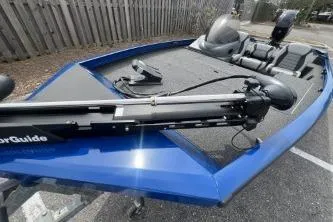 Slide: The Image of 2013 Lowe Stinger 175 boat, blue exterior, parked on asphalt, featuring a trolling motor. - 11