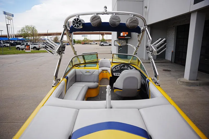 Slide: The Image of 2007 MasterCraft X10 boat with yellow and gray interior, parked outdoors. - 15