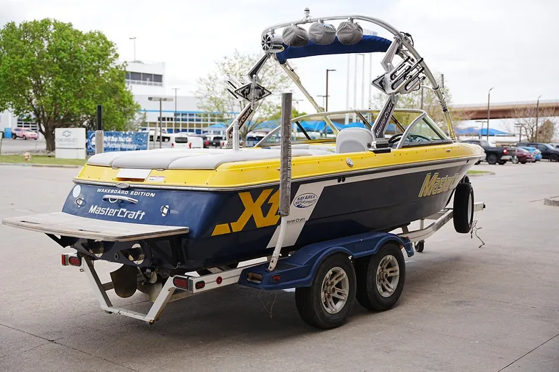 Slide: The Image of 2007 MasterCraft X10 wakeboard boat on trailer, parked outdoors. - 3