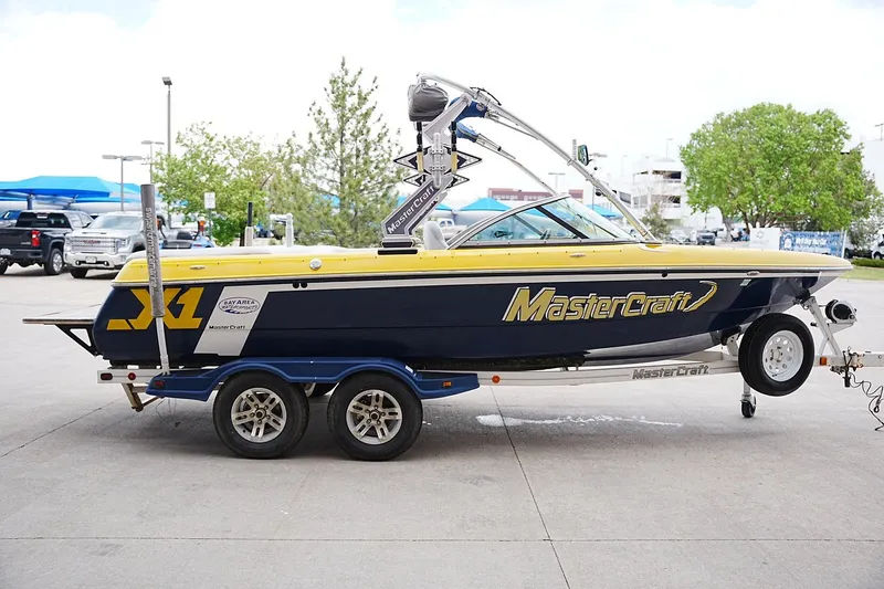Slide: The Image of 2007 MasterCraft X10 boat on trailer, parked outdoors, showcasing sleek design and vibrant colors. - 4