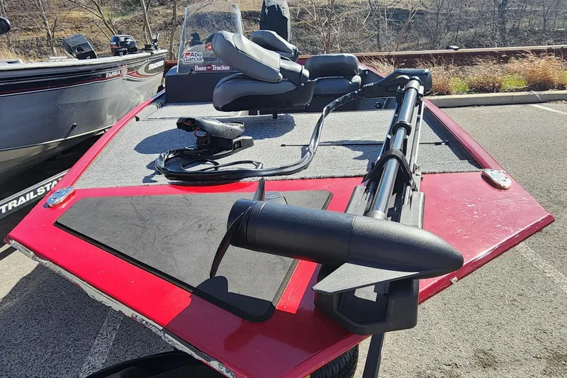 Slide: The Image of 2024 Tracker Bass Tracker Classic XL boat with trolling motor and seating, parked outdoors. - 2