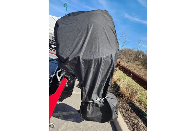 Slide: The Image of 2024 Tracker Bass Tracker Classic XL with covered outboard motor in a parking area. - 7