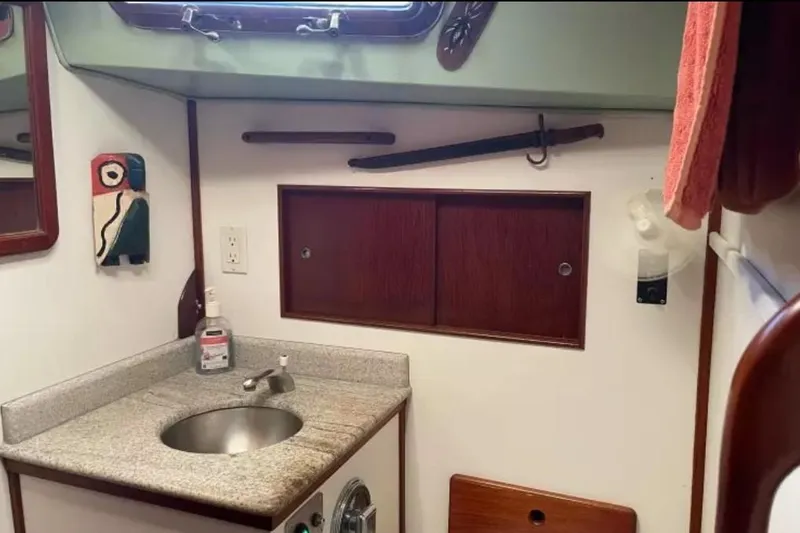 Slide: The Image of 1980 Morgan 462 yacht bathroom with sink, wooden cabinets, and nautical decor. - 16